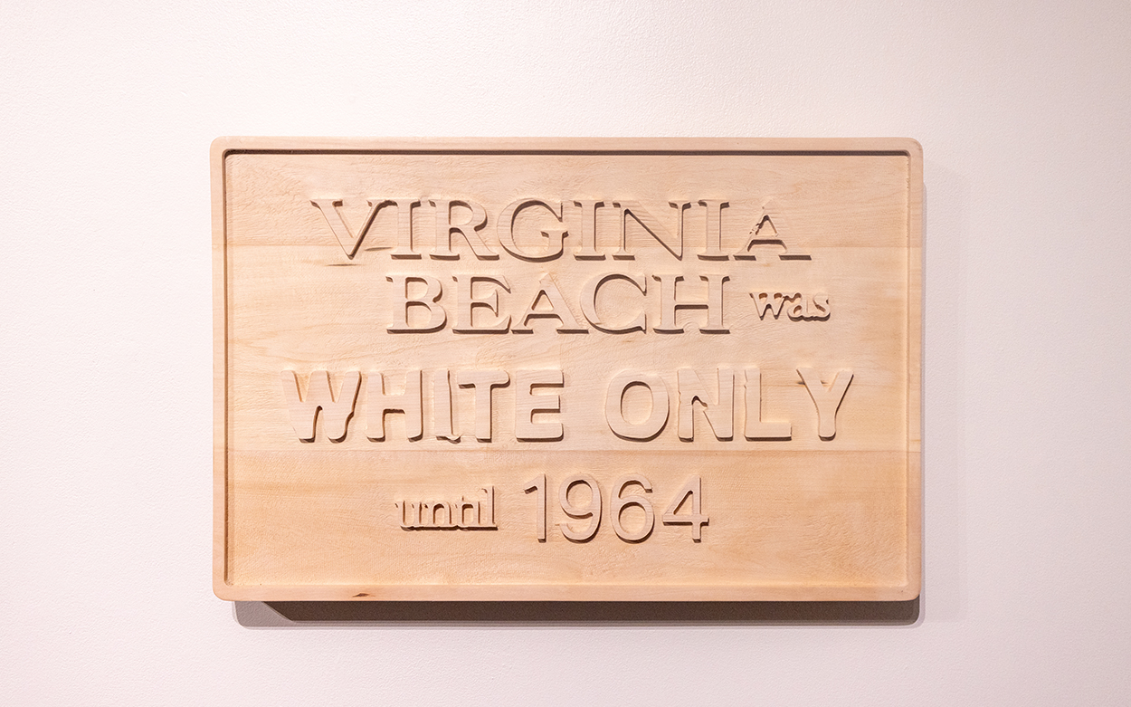 A wooden sign carved with the words: Virginia Beach was White Only until 1964