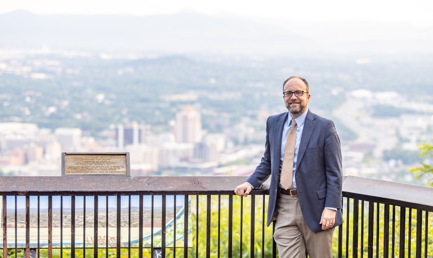 John Hull smiles for a photo at an overlook offering a sweeping view of downtown Roanoke