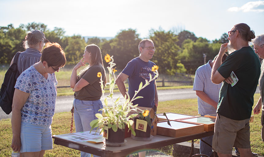 participants look at a table display at the Suburban Wild event. 