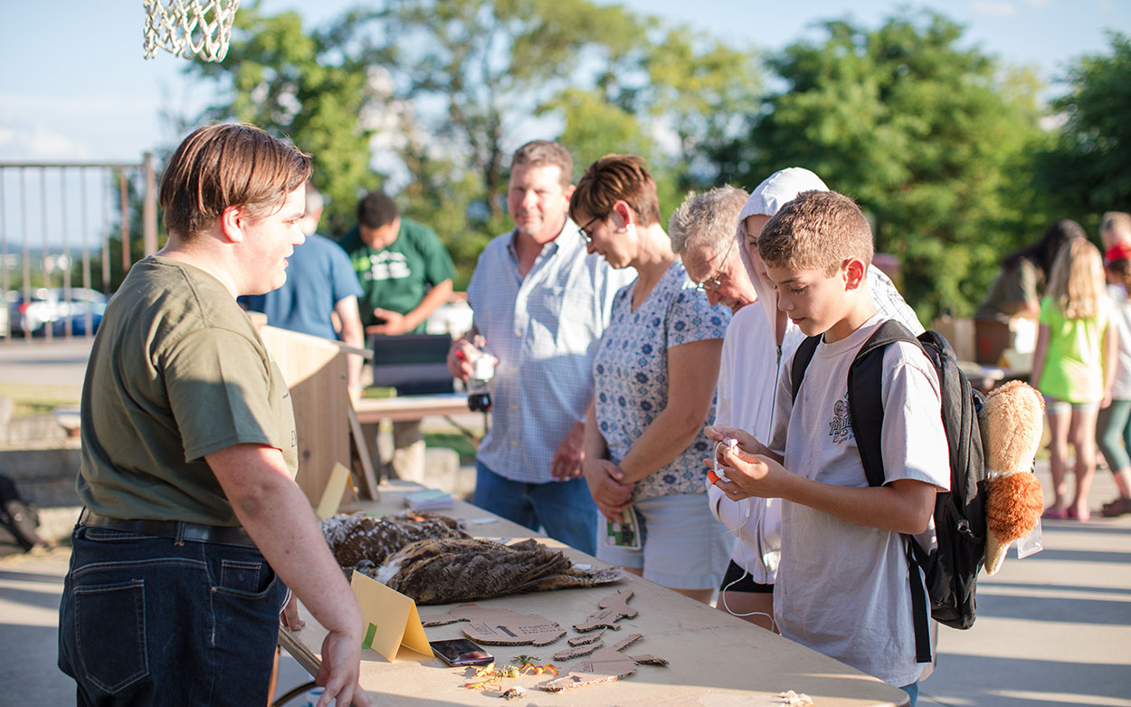 Student talks to participants at Suburban Wild event