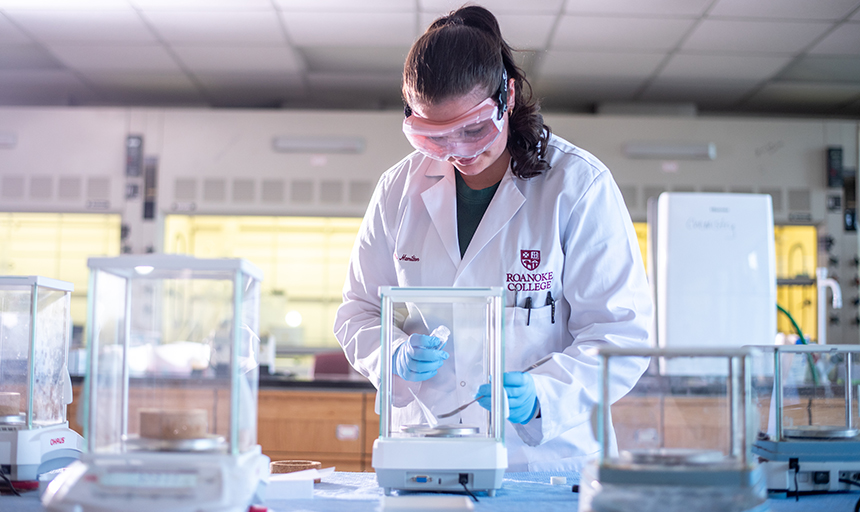 Young woman in white lab coat conducts research in laboratory