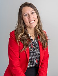 Headshot of a dark-haired woman in a red blazer