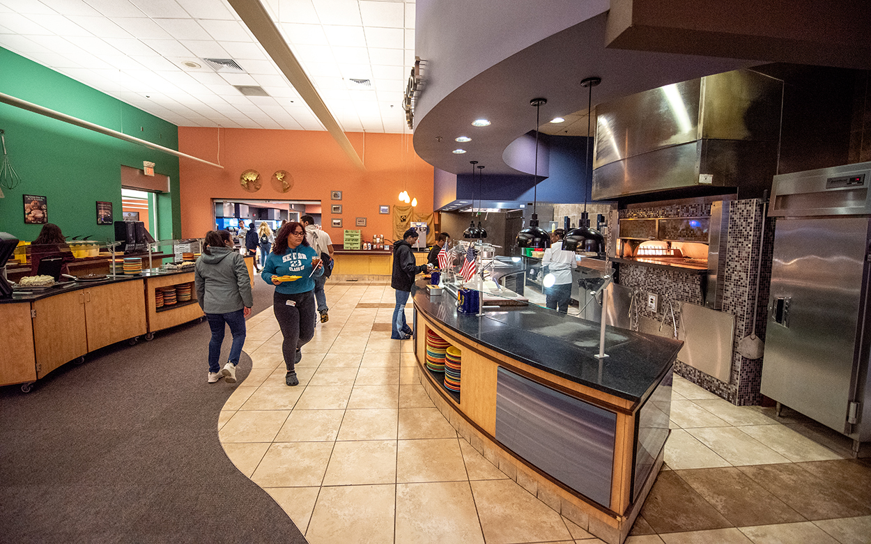 Two students approach the pizza station inside Sutton Commons