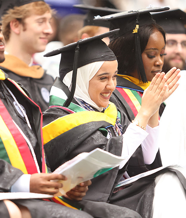 Huda Hashash smiles and applauds during her graduation from Roanoke College